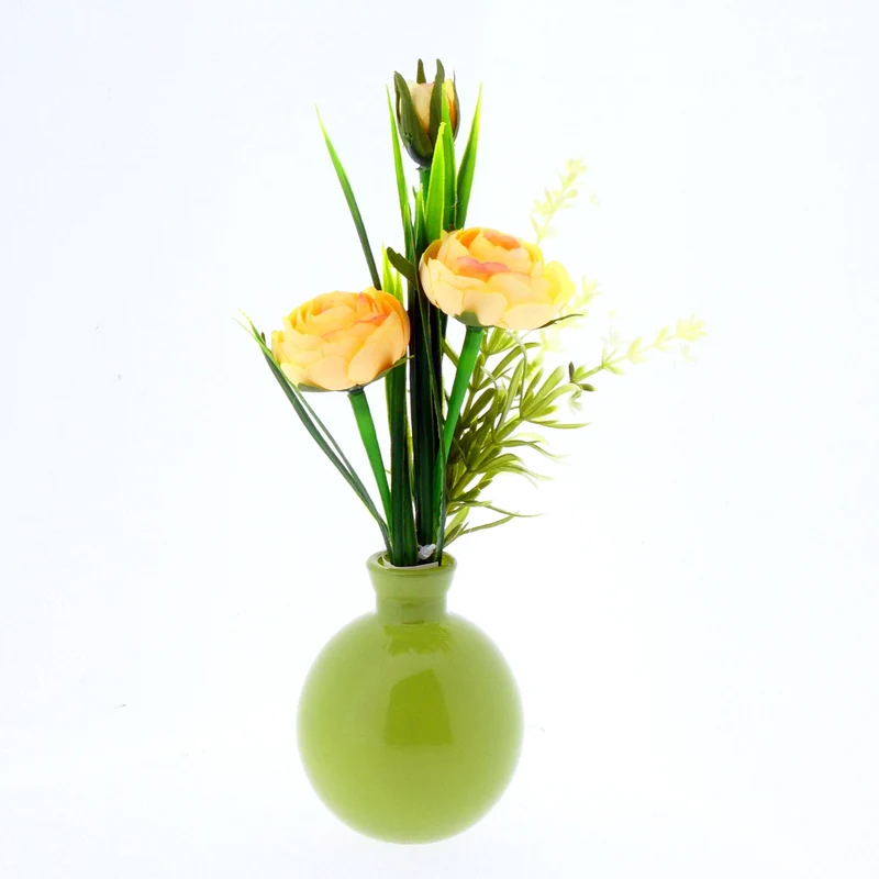 Ranunculus in green glass vase H22cm yellow