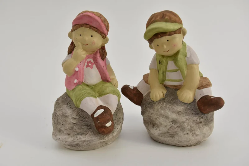 Kind zittend op steen 2 assortie 13x8,5x17cm keramiek Groen