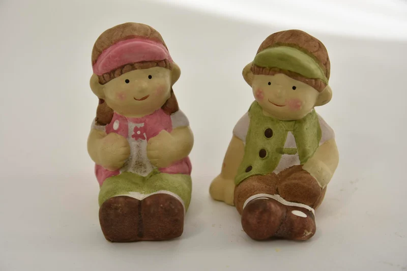 Kind met zittend 2 assortie 7x6x8cm keramiek Groen en Roze